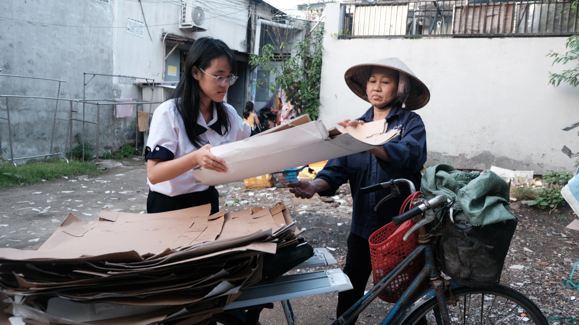 Sau giờ học, Đinh Trần Giáng My giúp mẹ sắp xếp lại đống ve chai vừa thu gom Sau giờ học, Đinh Trần Giáng My giúp mẹ sắp xếp lại đống ve chai vừa thu gom
