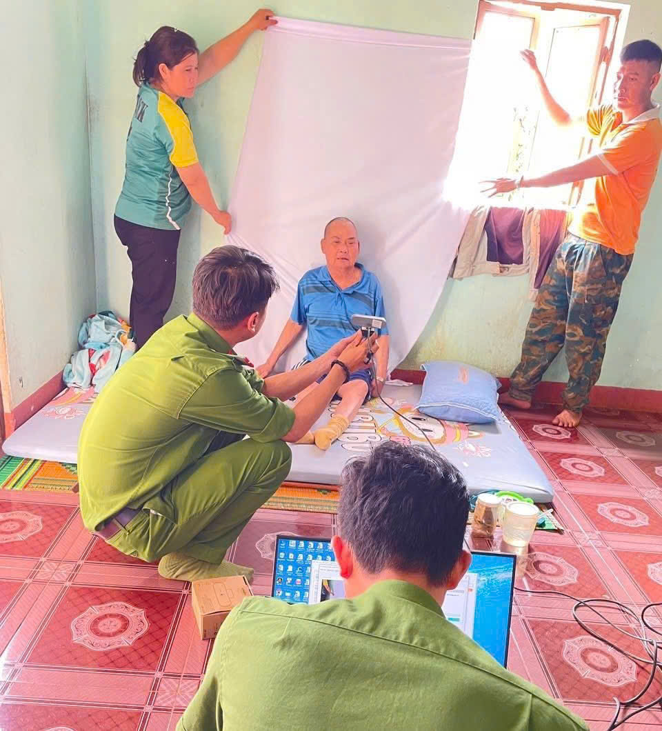 Công an xã Ia Phí đến tận nhà hỗ trợ cấp đổi thẻ cho đảng viên cao tuổi, sức khỏe yếu. (Ảnh Đỗ Thé Thành)