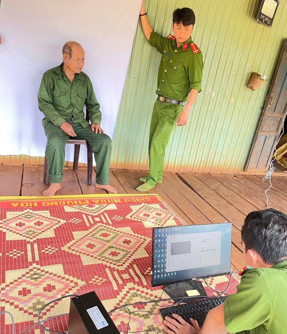 Công an xã Ia Phí đến tận nhà hỗ trợ cấp đổi thẻ cho đảng viên cao tuổi, sức khỏe yếu. (Ảnh Đỗ Thé Thành)