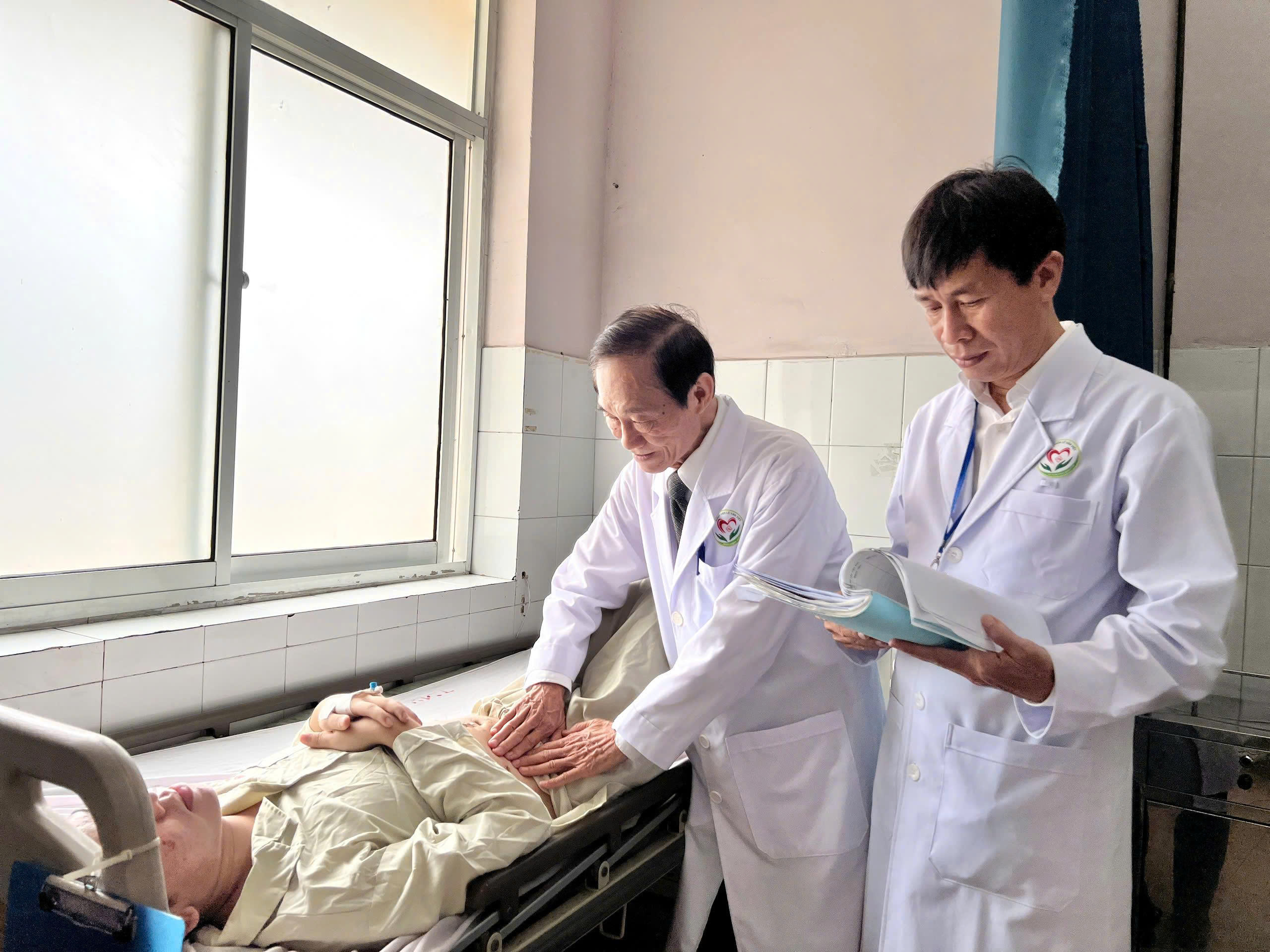 GS.TS.BS Nguyễn Công Minh, Cố vấn chuyên môn và BS.CK2 Nguyễn Văn Chức, Phó Giám Đốc bệnh viện thăm khám cho bệnh nhân sau phẫu thuật.
