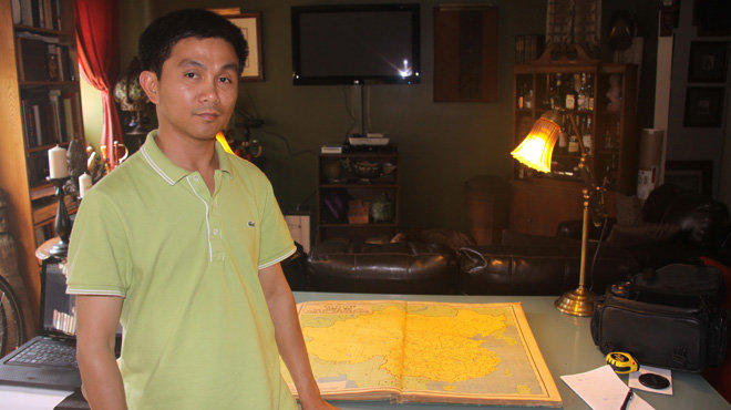 Trần Thắng bên cạnh tấm bản đồ do Trung Quốc ấn hành tại một cửa hàng bán đồ cổ ở New York (Hoa Kỳ) ngày 30-7